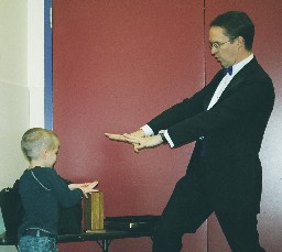 Richard Young the Magician teaching the birthday boy a trick